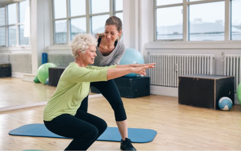 Accredited exercise physiologist assisting an older adult with balance training at a clinic in North Parramatta. Aged care exercise physiology helps seniors improve mobility and reduce falls risk.
