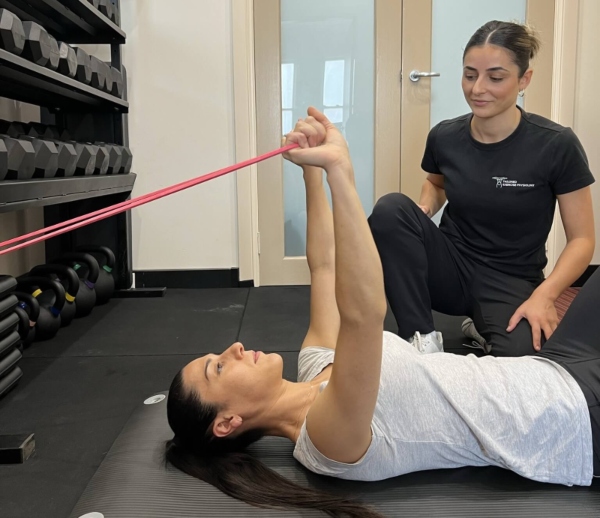 Exercise physiologist in North Parramatta, Taylor Mikaelian guiding resistance band rehabilitation